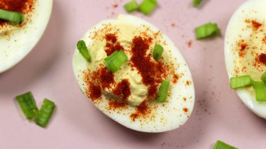 Pembe bir plaka üzerinde kırmızı biber ile meze olarak baharatlı ve acılı yumurta