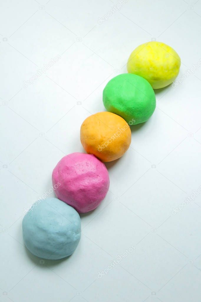 Homemade colorful clay on a white table.