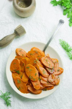 Tereyağı ve beyaz tabakta dereotu ile lezzetli ev yapımı sote havuç