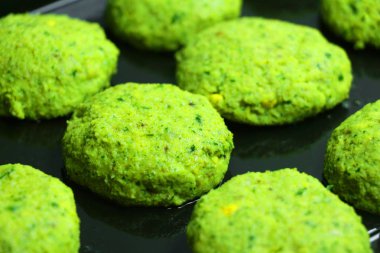 Fırın tepsisindeki pişirilmeli hazır çiğ çiğ falafel. Evde yemek. Sağlıklı pişirme kavramı.