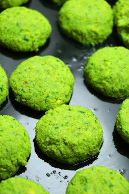 Fırın tepsisindeki pişirilmeli hazır çiğ çiğ falafel. Evde yemek. Sağlıklı pişirme kavramı.