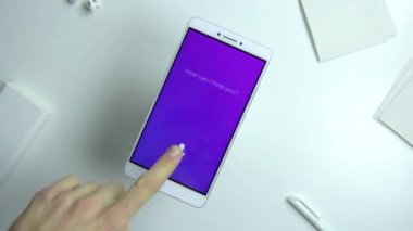 Akıllı kişisel asistan beyaz masa üzerinde Smartphone cep telefonu ile Office kullanan adam. Ses asistanı kavramı.
