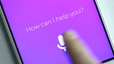 Akıllı kişisel asistan beyaz masa üzerinde Smartphone cep telefonu ile Office kullanan adam. Ses asistanı kavramı.