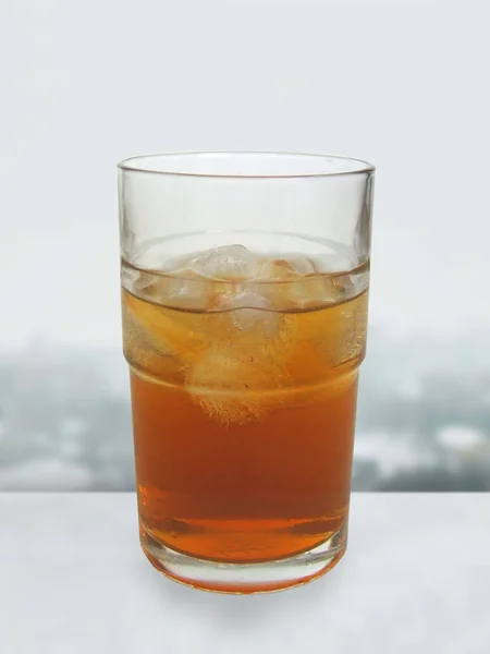 Kombucha Tea in a Glass Standing on a Withe Table over Window Background. Healthy homebrewed fermented drink with bacterial and yeast cultures. — Stock Photo, Image