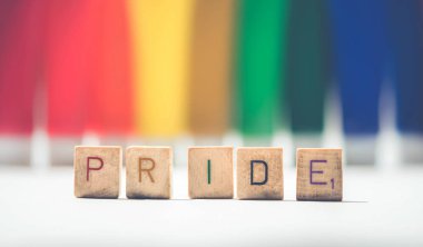 Gurur işareti bir gurur Lgbt gökkuşağı bayrağı arka plan üzerinde renkli ahşap alfabe harfleri ile yapılan.