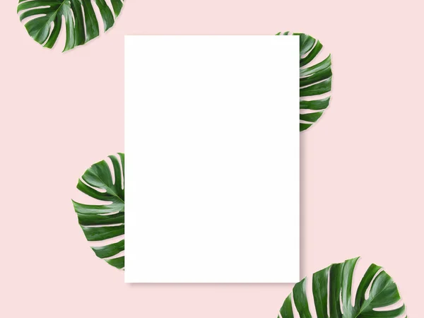 Une maquette stylisée. Modèle féminin de papeterie de bureau avec une carte papier vierge sur un fond rose pastel. Feuilles tropicales. Carte de vœux blanche avec espace vide . — Photo