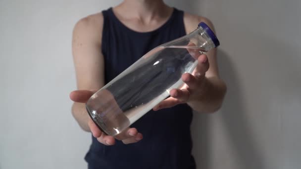 廃棄物ゼロの概念 ペットボトルの代わりにガラス瓶を使用する グリーンと意識的なライフスタイルのコンセプト 外出先で再利用可能な飲み物のアイデア 彼の前で再利用可能なガラスを持っている男 — ストック動画