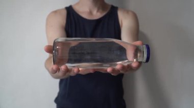 Sıfır atık kavramı. Plastik şişe yerine cam şişe kullanmak. Yeşil ve bilinçli yaşam tarzı kavramı. Go konteyner fikirleri üzerinde yeniden kullanılabilir içki. Önünde yeniden kullanılabilir cam tutan adam.