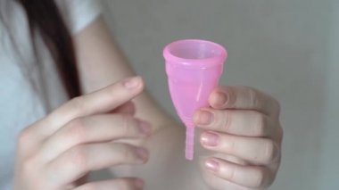 Yakın genç bir kadın el tekrar silikon adet fincan katlama. Sıfır atık adet hijyen konsepti. Dönemler için ekolojik alternatif.