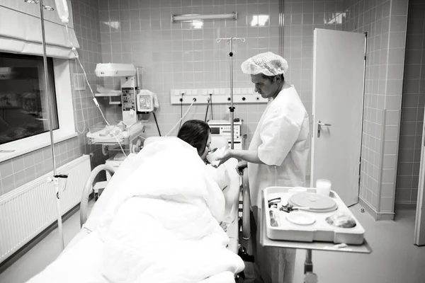 Young woman before giving birth with her husband in the ward