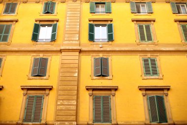 Kepenkli büyük pencereleri olan konut binasının cephesi. 