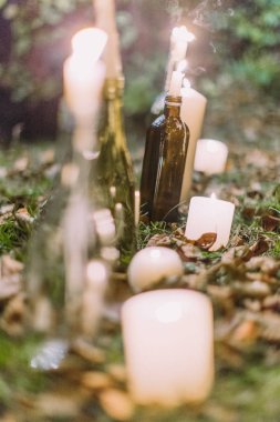 Yakın çekim fotoğraf çim aydınlatma mumlar ile cam şişe.