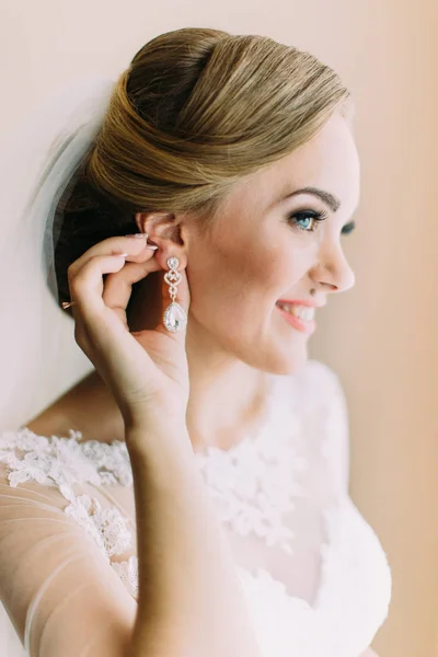 Retrato lateral de la novia sonriente tocando los pendientes . — Foto de Stock