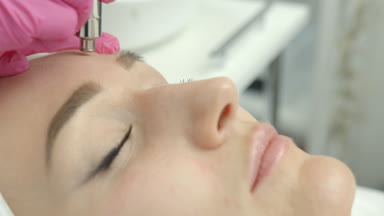 Çekici kadın güzellik salonunda vakum mikrodermabrazyon yordamı alıyor demektir. Yakın çekim yan görünüm. Kırışıklıkları koruma. 4 k görüntüleri.