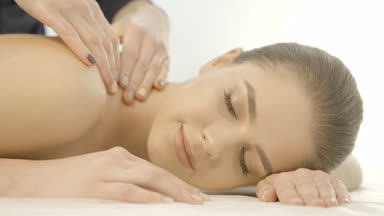 Hareketli kamera karşısında üzerinde ve kapalı gözler masajla memnun büyüleyici kadının arkasına. Spa salonu konumu. 4 k görüntüleri.