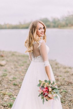 Sahilde vakit gülümseyen gelinin arkadan görünüm.