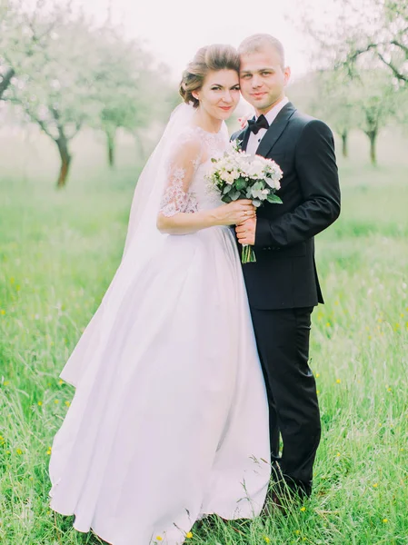 Jonggehuwden staan head-to-head op de achtergrond van het groene veld. — Stockfoto