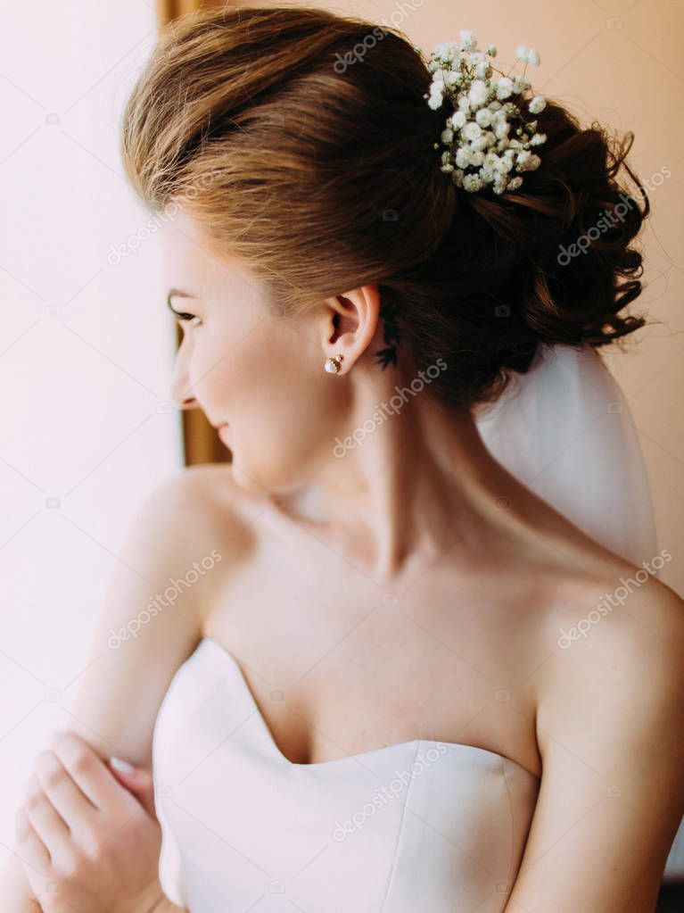 The close-up side portrait of the bride with flowers in her hair.