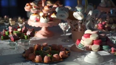 Düğün şeker büfesi. Farklı renkli ve lezzetli kek, pasta-pop'ları, kurabiye ve meyve ile dekore edilmiş macarons tatlı bar kaplı.