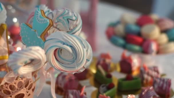 棒キャンディは異なるカラフルなクッキー、お菓子、結婚式でケーキで覆われています。マカロンのデザート スタンドで移動カメラ. — ストック動画