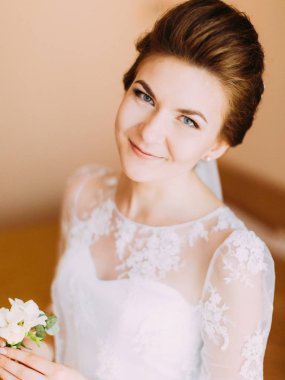 Beyaz Mini buket mutlu gülümseyen gelinle yakın çekim portresi.