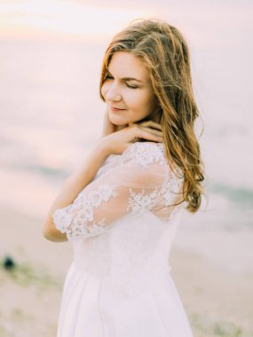 Gelin omuzlarını arka plan deniz, dokunuyor. Yan portre.