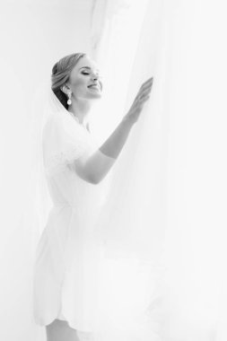 Mutlu gelin gelinlik asılı dokunuyor. Siyah fotoğraf.