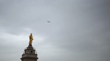 Roma, İtalya. Heykelin üzerinde uçan bir uçak. Bulutlu hava.