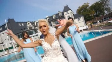 Güzel gelin ve damat ve onların nedime ve en iyi erkekler mutlulukla havuzun dans duygusal görüntüleri.