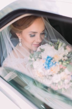 Arabada otururken düğün buket peçe altında kokulu güzel gelin.