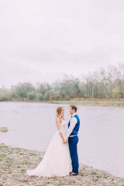 Yeni evliler sahilde vakit ise el ele tutuşarak.