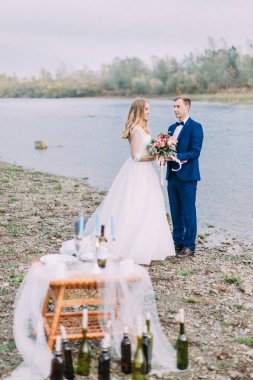 Sahilde düğün töreni. Yeni evliler el ele tutuşarak.