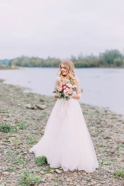 Sensibile foto a figura intera della bella sposa che tiene il bouquet di nozze. Posizione della spiaggia . — Foto Stock