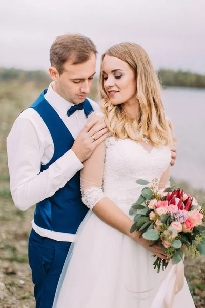 Yakın çekim sahilde vakit neşeli sarılma yeni evliler portresi.