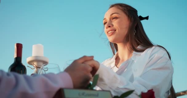 Mulher sorridente bonita está conversando com seu amante e de mãos dadas durante o jantar romântico ao ar livre. Filmagem 4k . — Vídeo de Stock