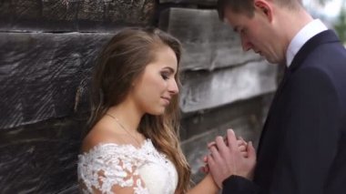 Yakın çekim damat usulca öpüşme büyüleyici gelini elinde hassas portresi.