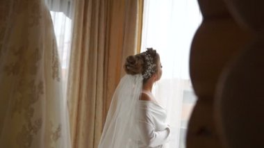 Pencereden bakarak Beyaz ipek elbise zarif sarışın gelinin arkadan görünüş.