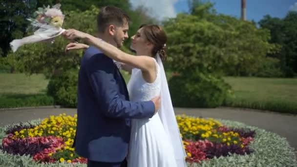 우아한 신혼 웃 고 아름 다운 피 정원에서 포옹의 측면 초상화. 결혼식 날. — 비디오