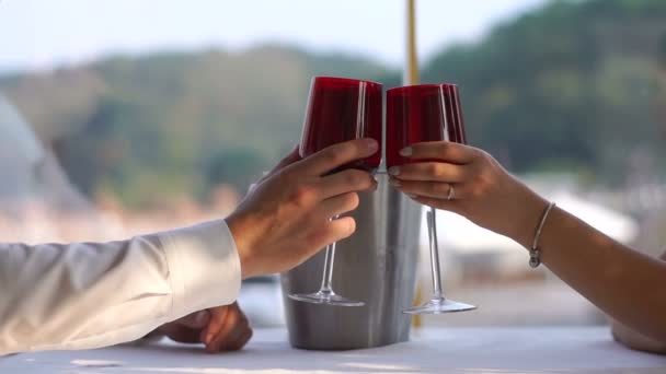Vista de cerca de la pareja de amantes tintinear vasos con vino y beber en el restaurante. Sin cara. . — Vídeos de Stock