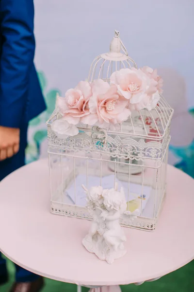 Preciosa jaula de hierro vintage derocada con flores rosas colocadas sobre la mesa . — Foto de Stock