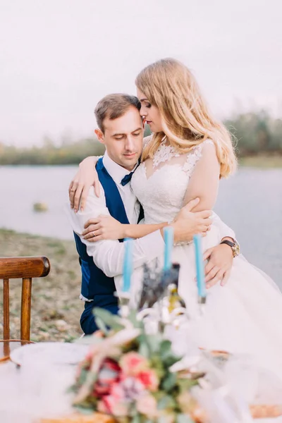 Sensible retrato al aire libre de la pareja recién casada abrazada. La ubicación de la playa . —  Fotos de Stock