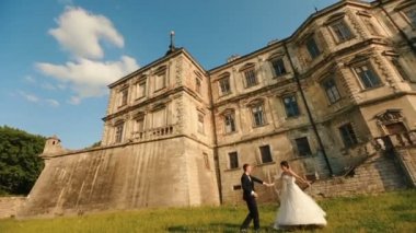 Neşeli şık yeni evli mutlu eski kalenin arka plan üzerinde dans ederken eğleniyor musun.