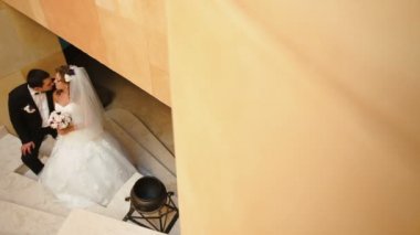 Şefkatle merdivenlerde öpüşme büyüleyici zarif yeni evli çift görünüm.