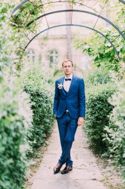 Stylishle damat bahçede giyinmiş..