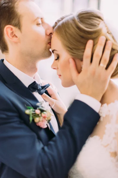Retrato de close-up. Groom está beijando a noiva na testa . — Fotografia de Stock