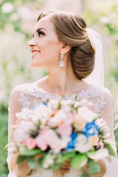 Potret samping pengantin wanita yang tersenyum memegang buket bunga pernikahan . — Stok Foto