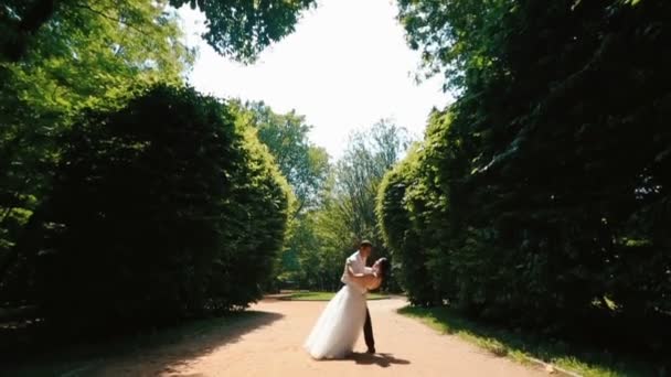Vista completa de la hermosa pareja feliz de recién casados bailando en el hermoso jardín . — Vídeo de stock