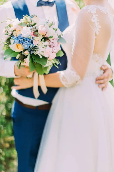 Foto de close-up do colorido buquê de casamento nas mãos dos recém-casados . — Fotografia de Stock