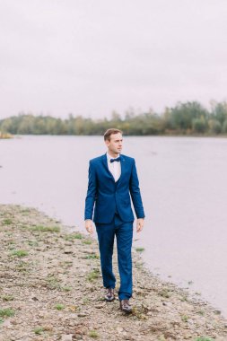 Sahilde yürüyüş damadın tam uzunlukta görünümü.