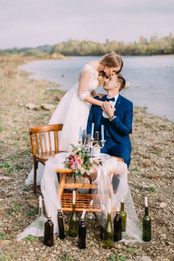 Güzel gelin oturma damat Alnından öpüyor. Plaj konumu.